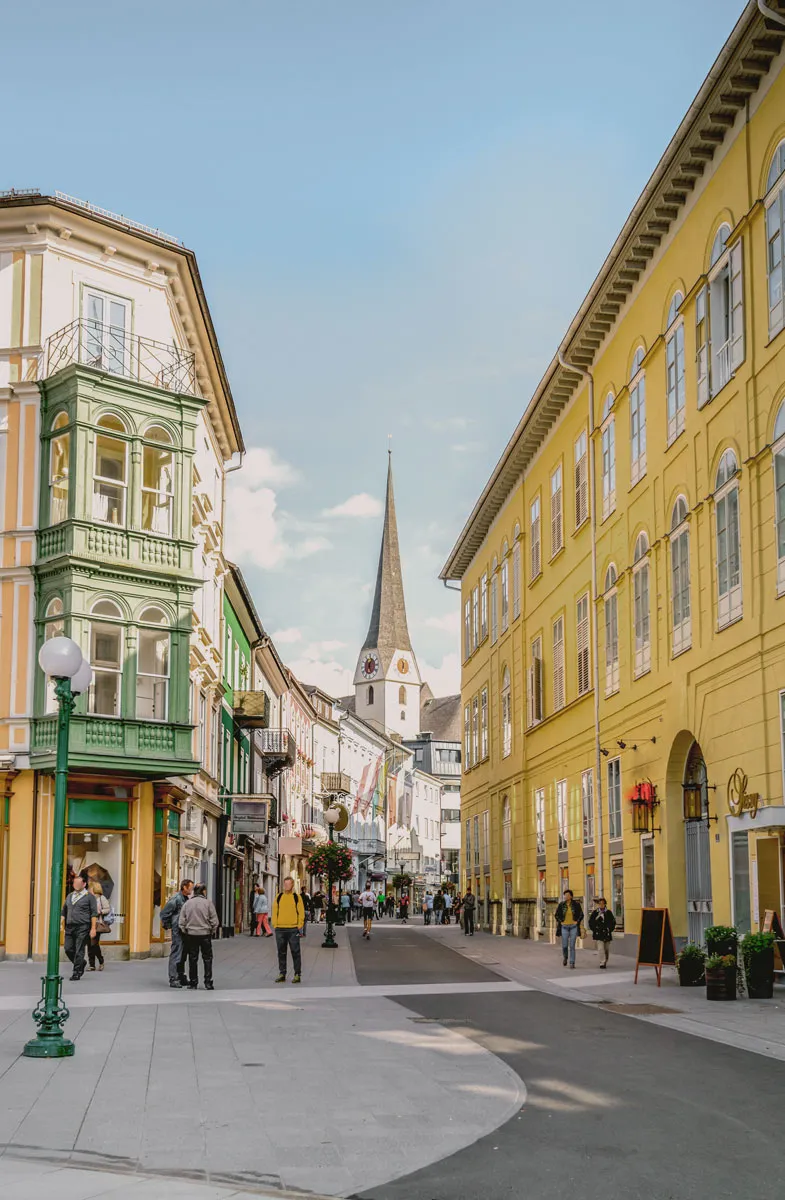 Schmale Gasse in der Kulturstadt Bad Ischl, gesäumt von prachtvollen Fassaden, im Hintergrund erhebt sich ein Kirchturm