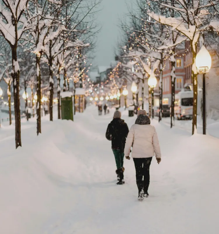 Zwei Personen schlendern durch verschneite Straßen im Kurort Bad Ischl, unweit des Grand Elisabeth Hotels