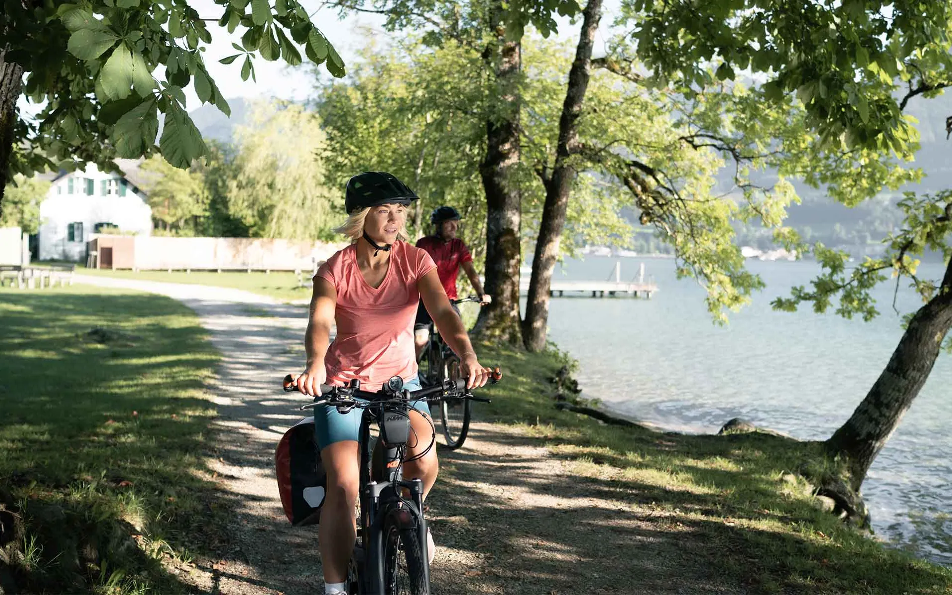 Paar auf E-Bikes beim Kaiserliche Radtage Angebot des Grand Elisabeth Hotels Bad Ischl, Radfahren entlang des Wolfgangsees im Salzkammergut