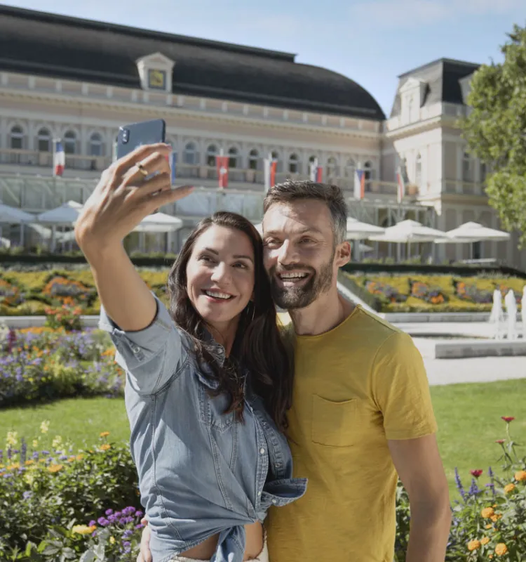 Ein Paar posiert für ein Selfie vor den historischen Sehenswürdigkeiten Bad Ischls