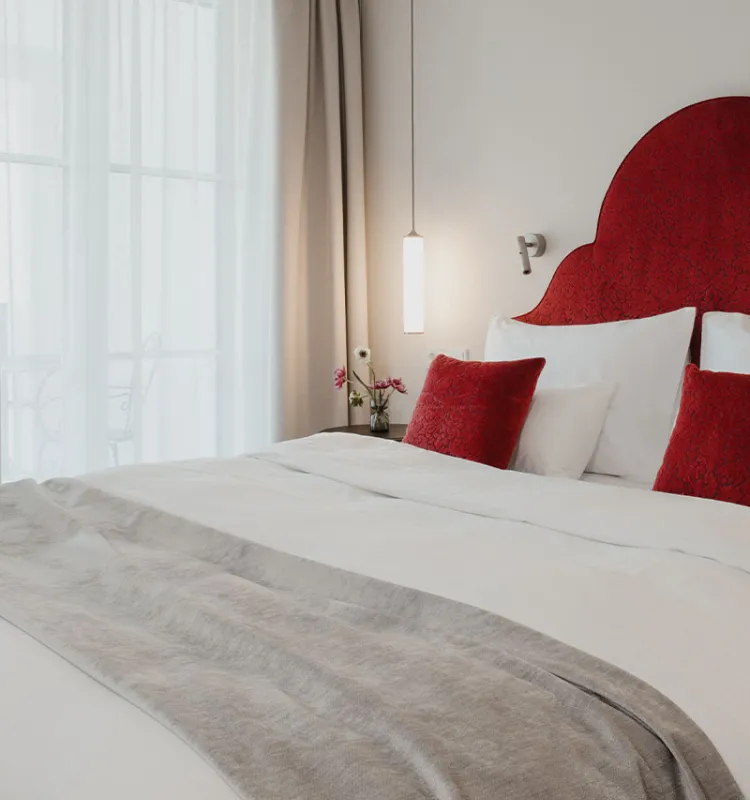 Innenansicht Classic Doppelzimmer mit Bett, Nachttisch und Balkonzugang im Grand Elisabeth Hotel in Bad Ischl.