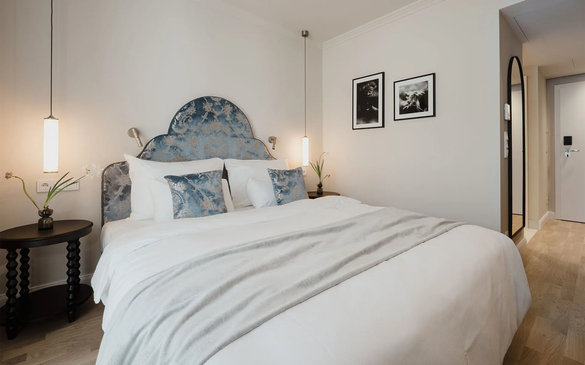 Classic Doppelzimmer mit großem Bett, blauem Kopfteil und stilvollen Details im Grand Elisabeth Hotel in Bad Ischl.