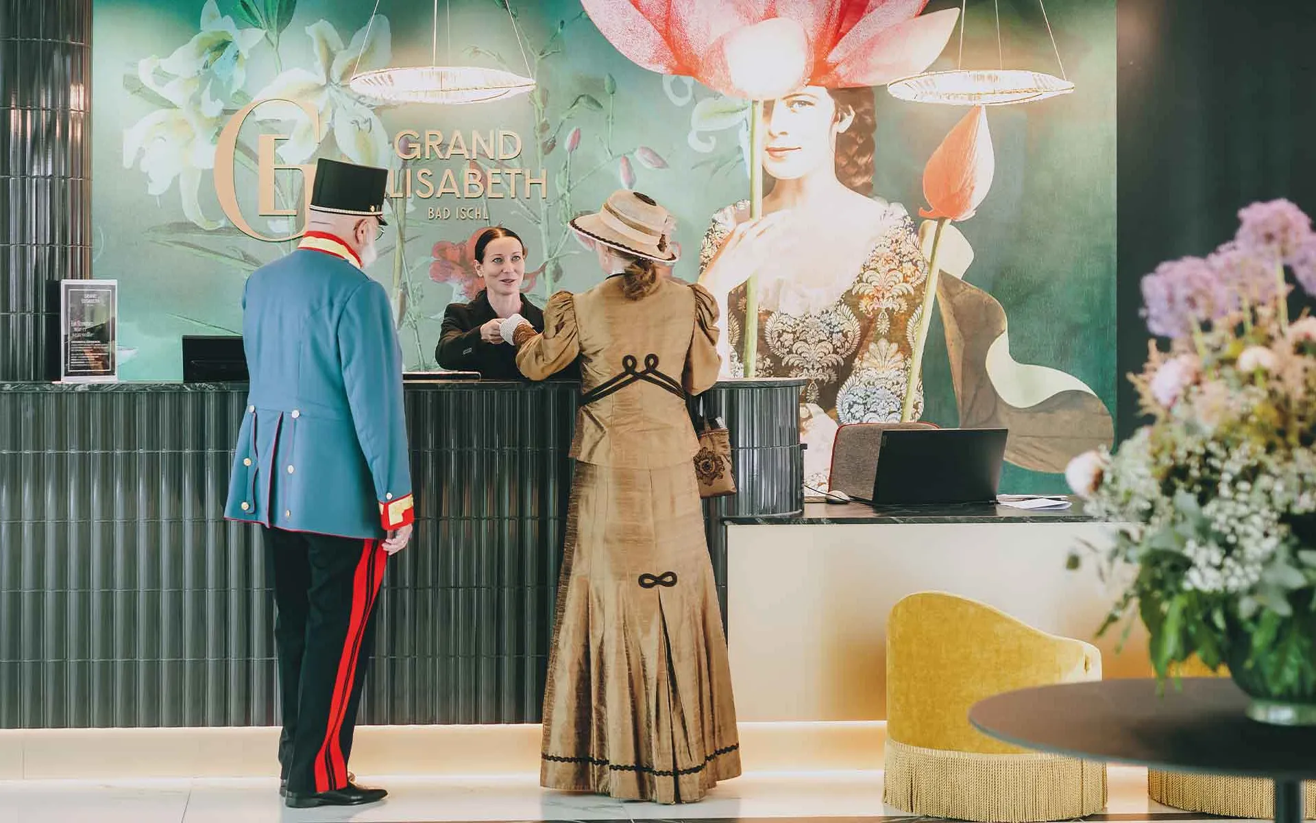Porträt von Gästen in historischer Kleidung an der Rezeption im Grand Elisabeth Hotel in Bad Ischl.