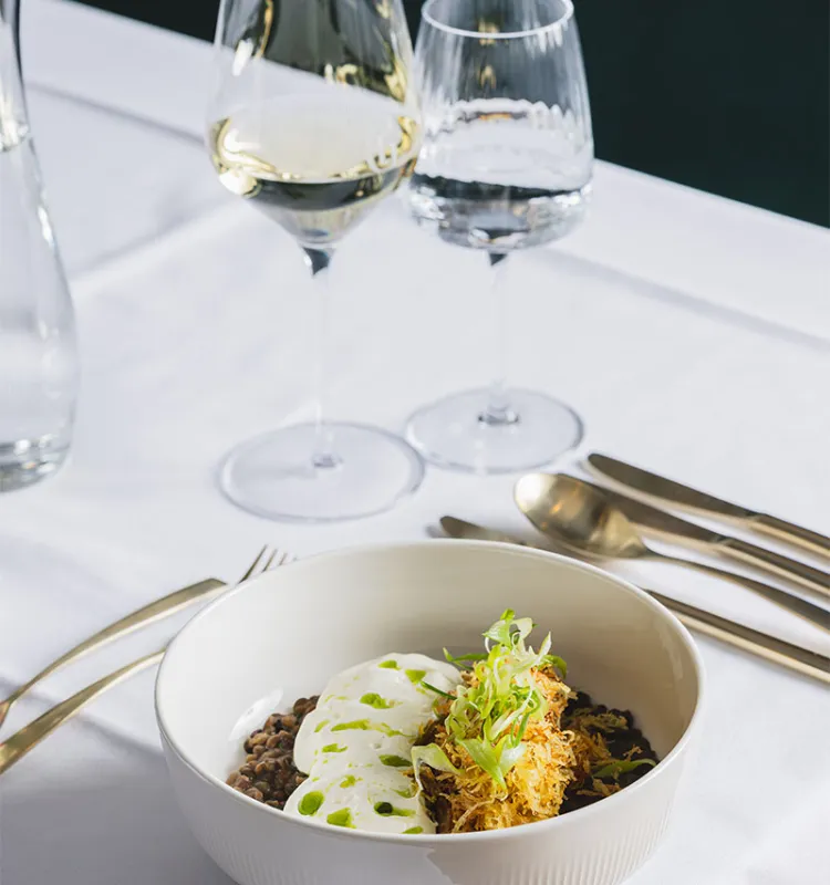 Gedeckter Tisch mit Hauptgang und Weinglas im Designhotel Grand Elisabeth