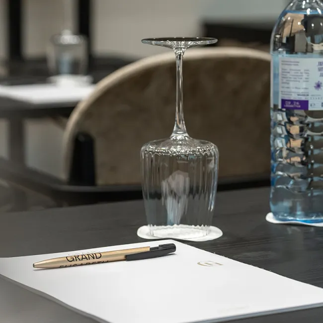Konferenztisch mit Wasserflasche, Glas und Schreibblock im Grand Elisabeth