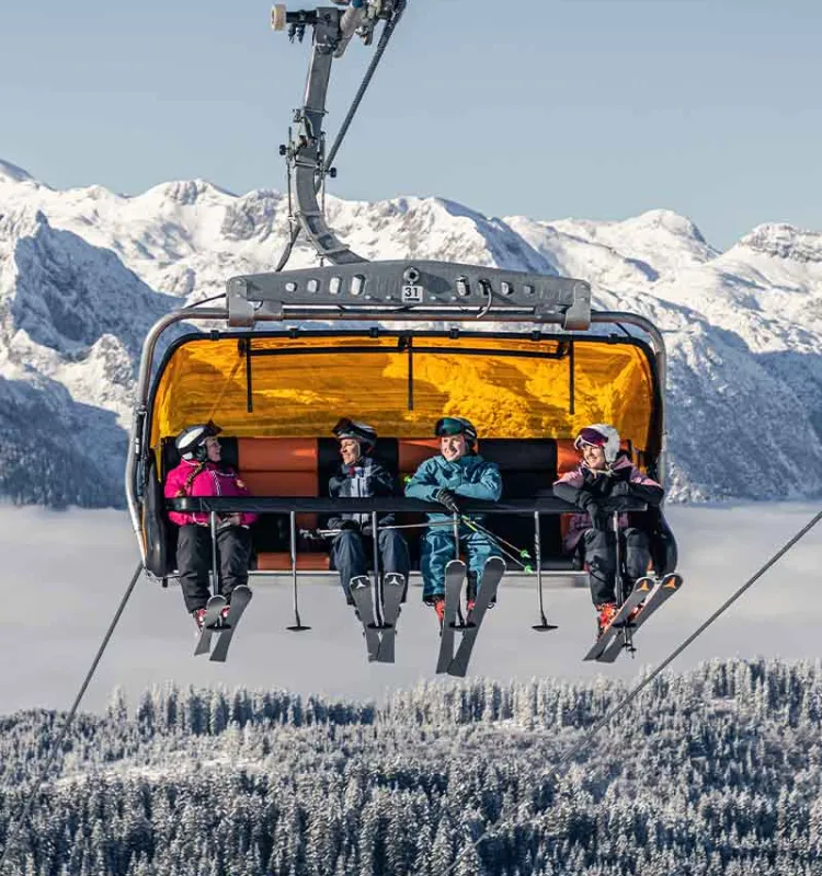 Skifahrer im Sessellift Dachstein West beim Snow Adventure Skiurlaub des Grand Elisabeth Hotels im Salzkammergut Österreich