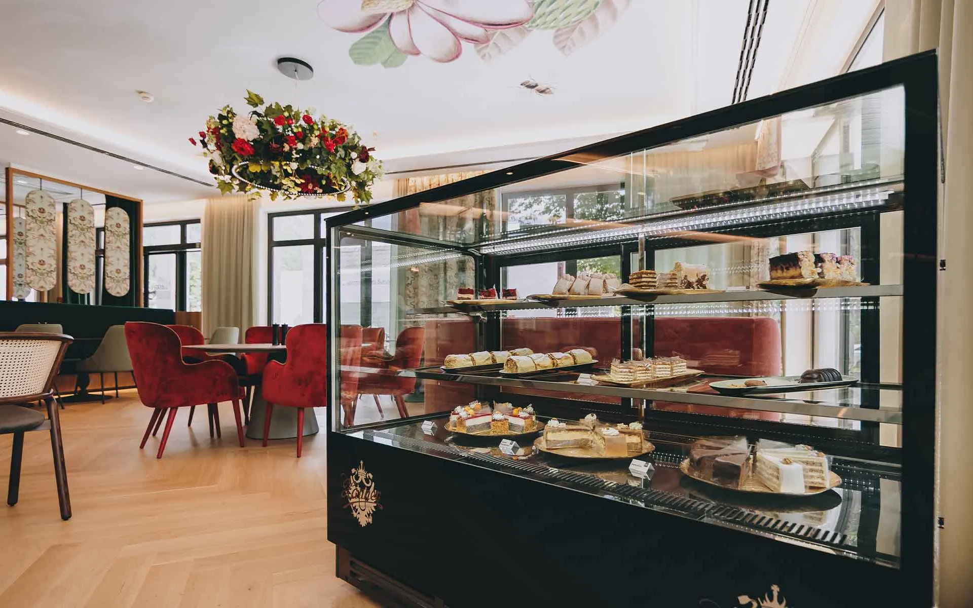 Porträt einer reich gefüllten Kuchenvitrine mit Blick auf das Grand Liberté im Grand Elisabeth Hotel Bad Ischl.