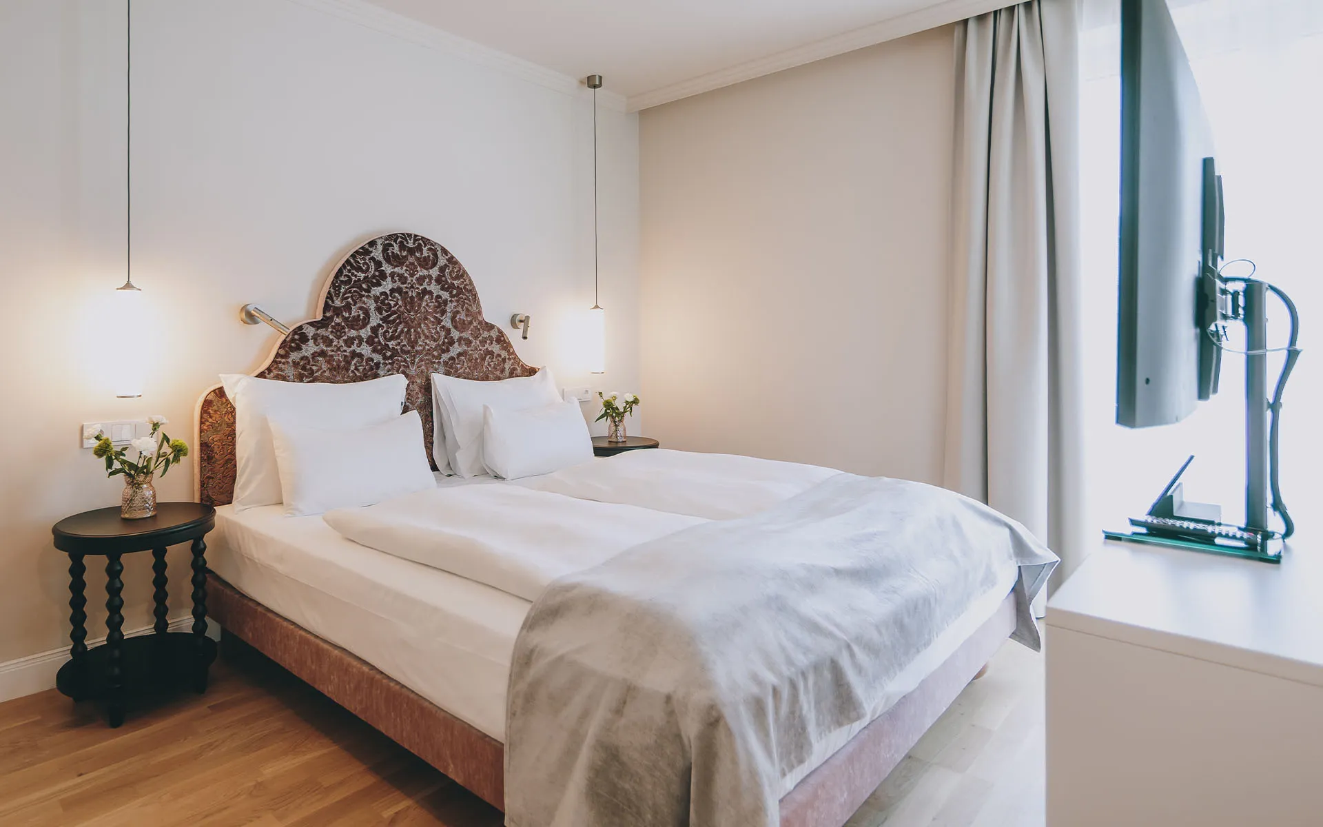 Blick auf das Doppelbett und TV im Superior Zimmer des Grand Elisabeth