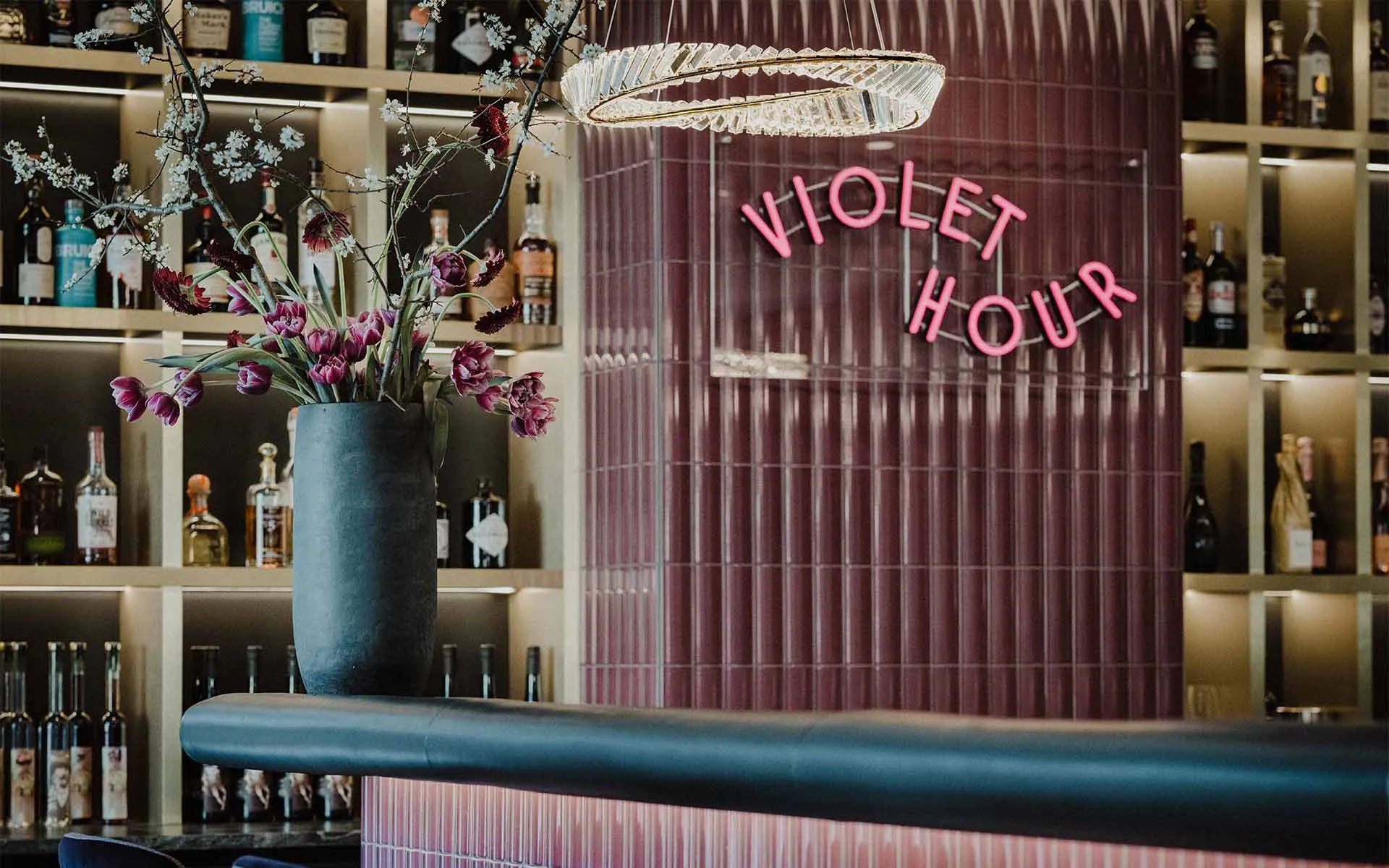Die stilvolle Bar Violet Hour im Grand Elisabeth Bad Ischl mit floraler Dekoration und Spirituosenauswahl