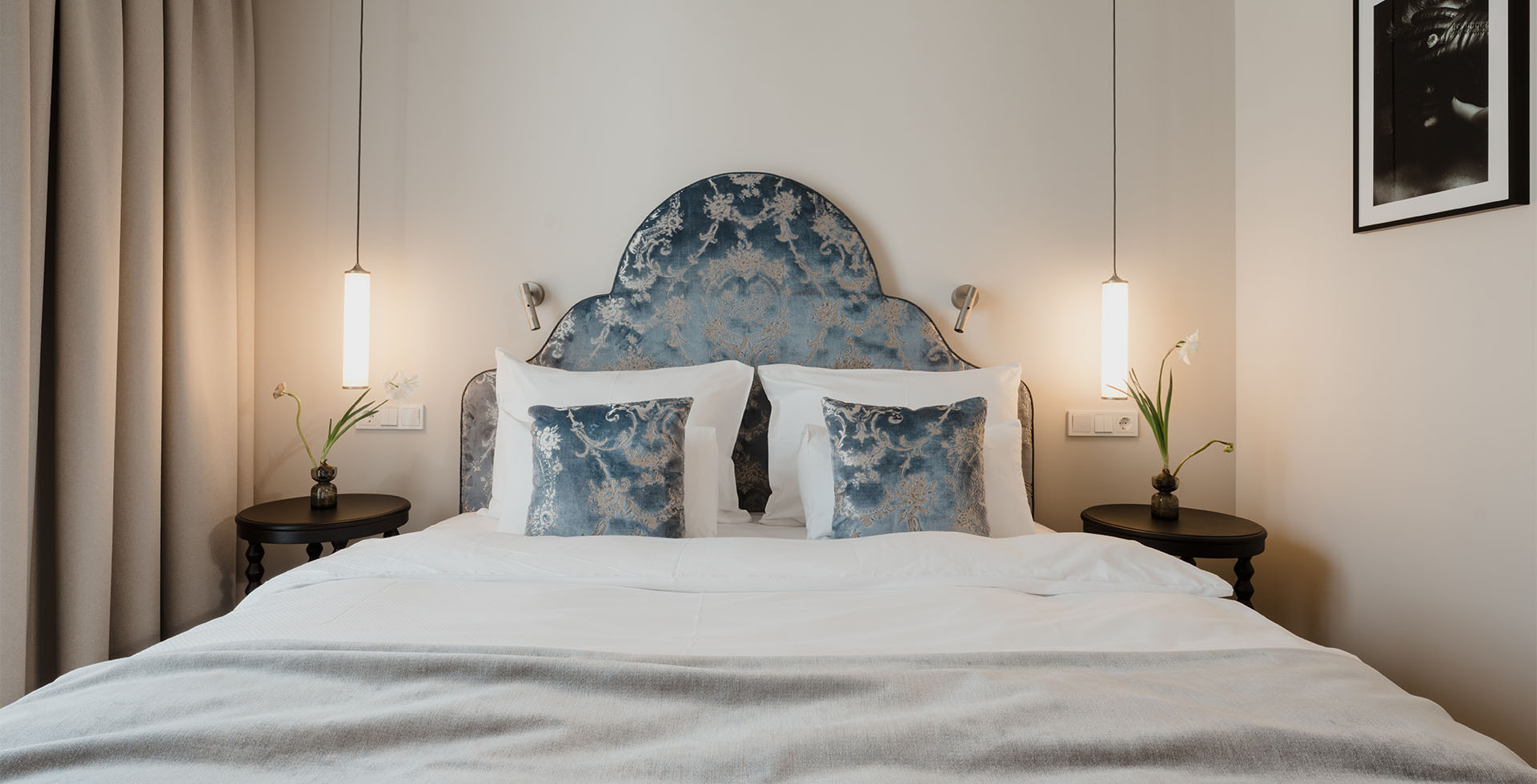 Doppelbett mit gemustertem Kopfteil und eleganter Beleuchtung im Classic Doppelzimmer Grand Elisabeth Hotel in Bad Ischl.