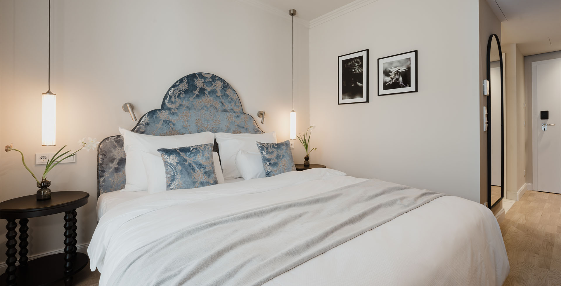 Blick auf das Combi Classic Doppelzimmer im Grand Elisabeth Hotel in Bad Ischl mit blauen Kissen und floralen Details.