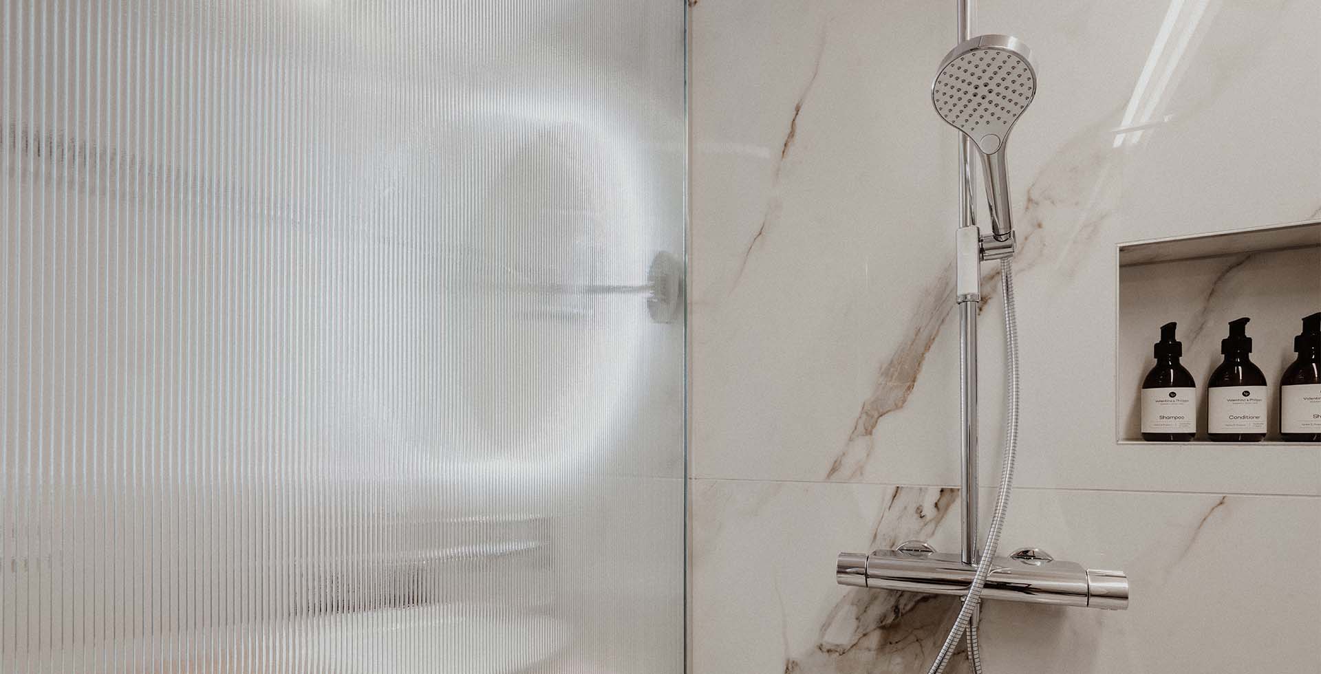 Luxuriöse Dusche mit Handbrause, Marmoroptik und hochwertigen Pflegeprodukten im Grand Elisabeth Hotel in Bad Ischl.