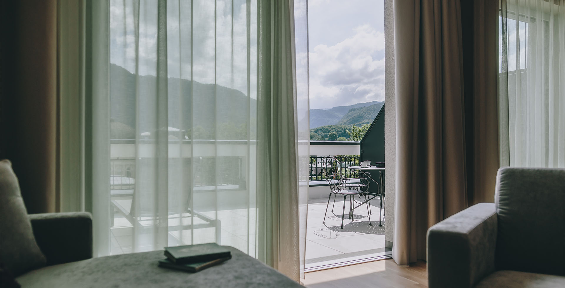 Panorama-Ausblick von der Kaiser Suite im Grand Elisabeth mit Terrasse, Sitzmöbeln und Blick auf die Alpenlandschaft im Salzkammergut.