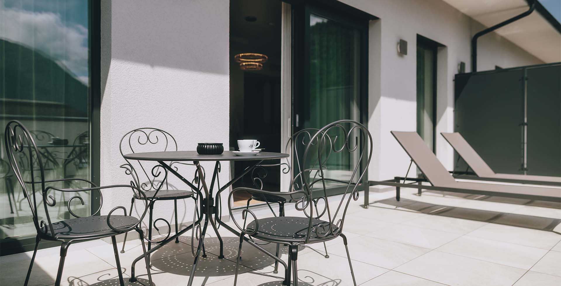 Terrasse der Kaiser Suite im Grand Elisabeth Hotel in Bad Ischl mit Sitzgarnitur und Sonnenliegen, ideal für ein Frühstück im Freien.