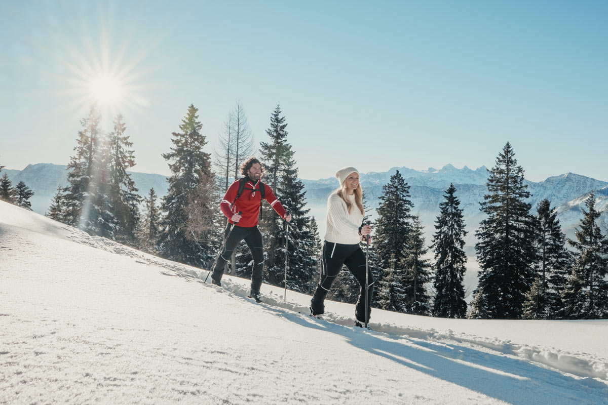 Zwei Menschen beim Winterwandern in der verschneiten Berglandschaft der Region Bad Ischl